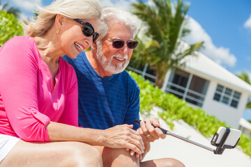 Senior Caucasian couple using selfie stick on beach