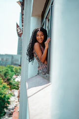 Wall Mural - black girl sitting on the edge of the window