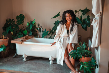 Wall Mural - black woman relaxing in her room wearing a white robe