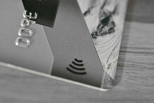Contactless Bank Card With An Image Of A Transmission Signal On A Gray Solid Background.
