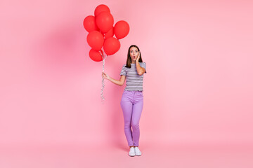 Sticker - Photo of attractive impressed young woman dressed striped clothes holding many red balloons arm cheek isolated pink color background