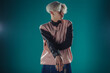 © qunica.com - Young adult man in casual outfit wear looking at camera, holding skateboard near face and standing at studio on blue background