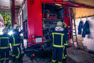 Wall Mural - Group of firefighters preparing and inspecting pressure and water in the fire truck inside the fire station