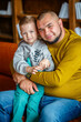 © popovatetiana - Portrait of adorable father and son sitting on the sofa at home