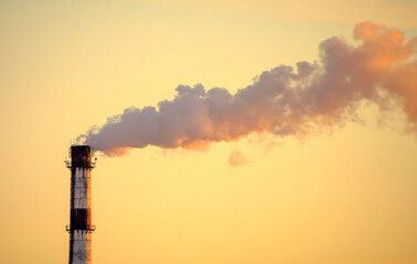 Photo of factory pipe with smoke at sunset