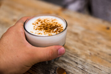 Sticker - Man holding a glass of Chai Tea on a wooden surface