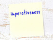 © iushakovsky - Yellow sticky note on wooden wall with handwritten word imperativeness