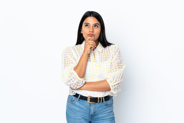 Wall Mural - Young latin woman woman isolated on white background having doubts while looking up