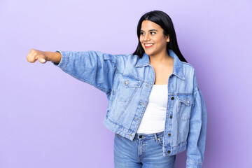 Wall Mural - Young latin woman woman over isolated background giving a thumbs up gesture