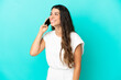 © luismolinero - Young caucasian woman isolated on blue background keeping a conversation with the mobile phone with someone