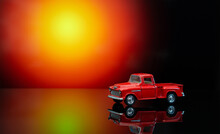 Vintage Toy Pickup Truck On A Glossy Surface. Lorry With A Body On The Back Of A Light Orange Spot.
