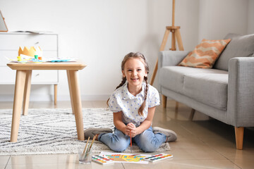 Wall Mural - Little girl painting with watercolor paints on floor at home