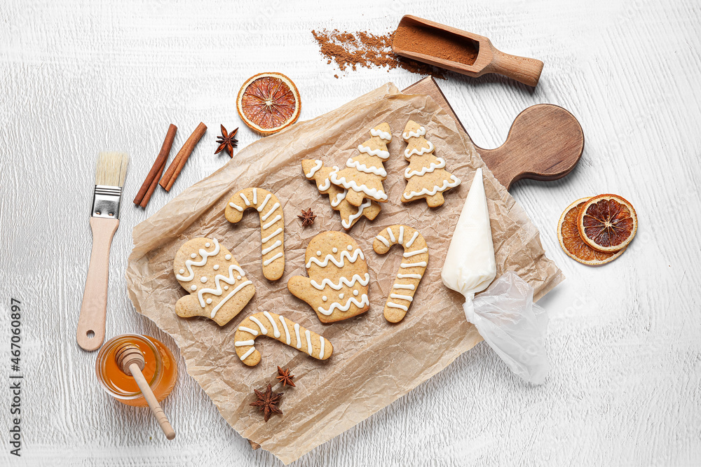 Board with Christmas gingerbread cookies on light background