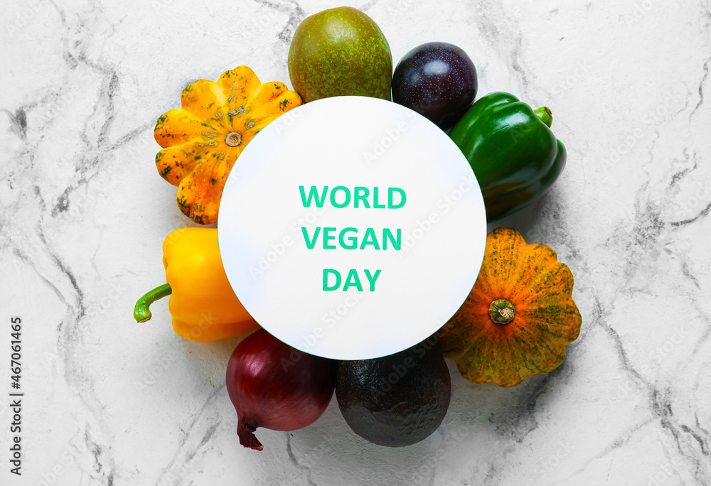 Card with text WORLD VEGAN DAY, fruits and vegetables on light background