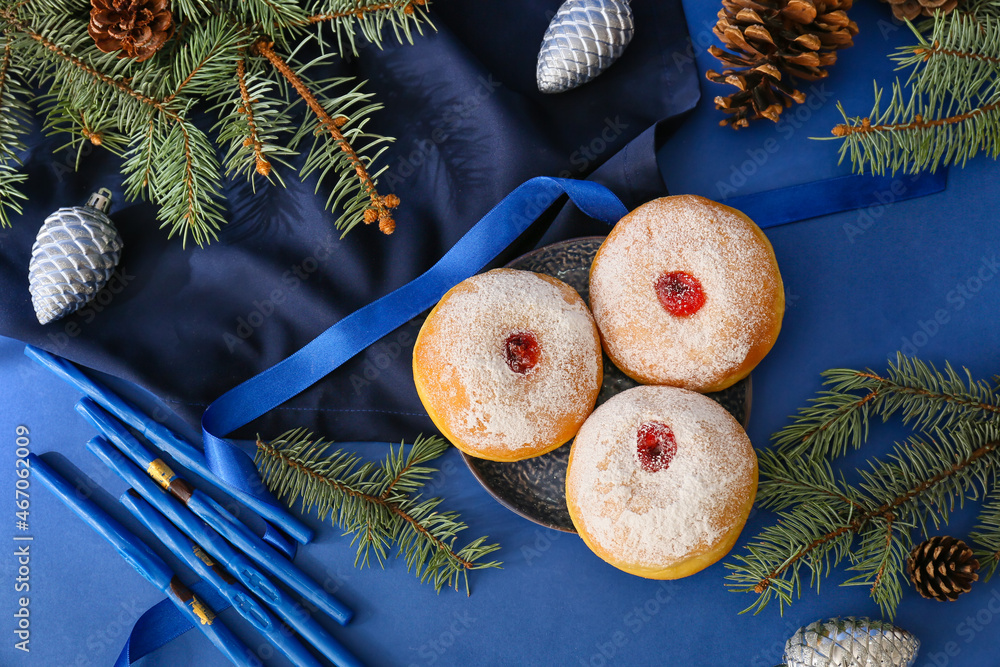 Sufganiyah for Hanukkah celebration with Christmas decor on color background