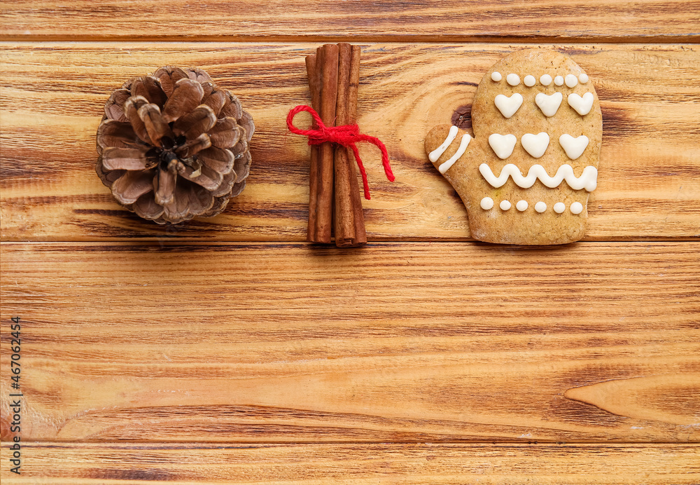 Cone pine, cinnamon and cookie on wooden background