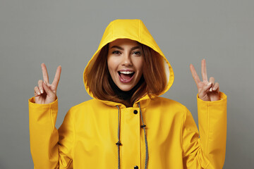 Wall Mural - Happy caucasian girl in yellow raincoat with hood