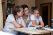 © DariaTrofimova - Young mother helping   daughters with lessons