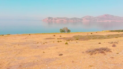 Wall Mural - Aerial approaching view scenic blue lake panorama with island on horizon . Armenia Sevan peninsula landscape lake coastline