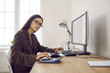 © Studio Romantic - Busy financial accountant working in office. Young woman in spectacles with serious face expression sitting at desk with modern computer, working with business accounts and doing important calculation
