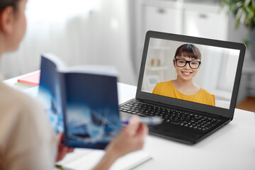 Poster - distant education, school and people concept - female math teacher with student girl on laptop computer screen and book having online class at home