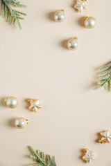 Wall Mural - Minimal Christmas composition. Golden balls, stars, fir branches on beige table. Elegant Vertical Christmas background. Flat lay, top view, copy space