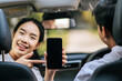 © Johnstocker - a woman and a man sitting in a car and looking at a cell phone