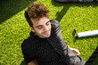 Young attractive man lying on artificial grass and relaxing