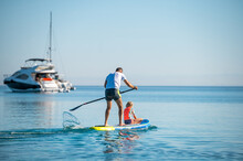 Father And Daughter Riding SUP Stand Up Paddle On Vacation.