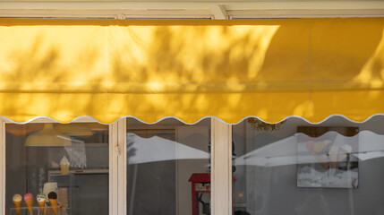 Poster - yellow awning of shop. canvas blind roof over the shop windows.