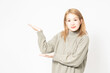 © garage38 - 案内のジェスチャーをするセーターを着た若い女性
