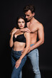 © LIGHTFIELD STUDIOS - sexy man hugging seductive woman in jeans and bra on black