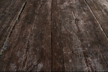 A perspective view of the old wooden jetty flooring. Aged shabby boards of brown color. There is a lichen. Background. Texture.