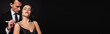 © LIGHTFIELD STUDIOS - passionate woman with closed eyes near elegant man touching strap of her dress isolated on black, banner