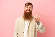 © luismolinero - Young reddish caucasian man isolated on pink background happy and counting four with fingers