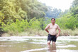© AlivePhoto - Fat Asian man standing alone in the river