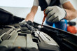 © Drazen - Close-up of car mechanic checks oil level during engine maintenance at service workshop.