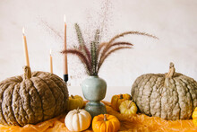 Halloween Table Decorated With Burning Candles And Pumpkins