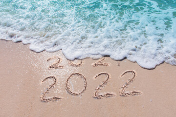 Wall Mural - message year 2021 replaced by 2022 written on beach sand background. good bye 2021 hello to 2022 hap