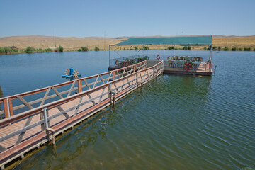 Landscape of an mountain lake in front of mountain range. Glorious lake landscape. The collaboration of blue and green. Restaurant and bridge in the middle of the lake . View of Abant Lake Golu .