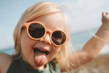 Funny Kid Sticking Out Tongue Playing Outdoor Happy Emotional Child In Sunglasses 3 Years Old Baby Family Vacations