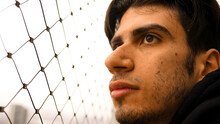 Close-up Shot Of Young Man Beside Chain Fence