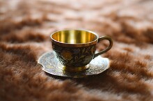Golden Cup And Saucer On Textile