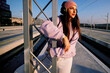 © chika_milan - A teenage girl is leaning on the metal construction at the train station and enjoying the music.