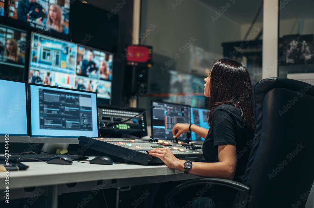 Young beautiful woman working in a broadcast control room on a tv ...