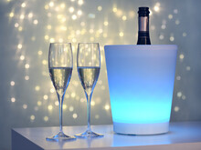 Two Glasses Of Champagne Against Blurred Lights