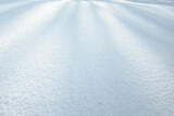 Fototapeta  - Biała powierzchnia śniegu. Faktura, struktura, głębia ostrości, tło, naturalne światło, cienie i blaski. Zima.