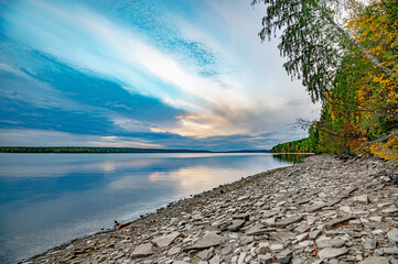 Wall Mural - autumn landscape, bright colorful leaves on the rocky riverbank.