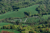 Fototapeta  - A winding road among fields and forests, Bieszczady Mountains, Poland