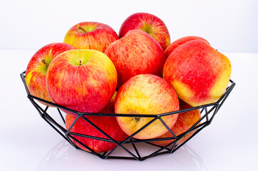 Ripe sweet apples in black metal basket. Studio Photo